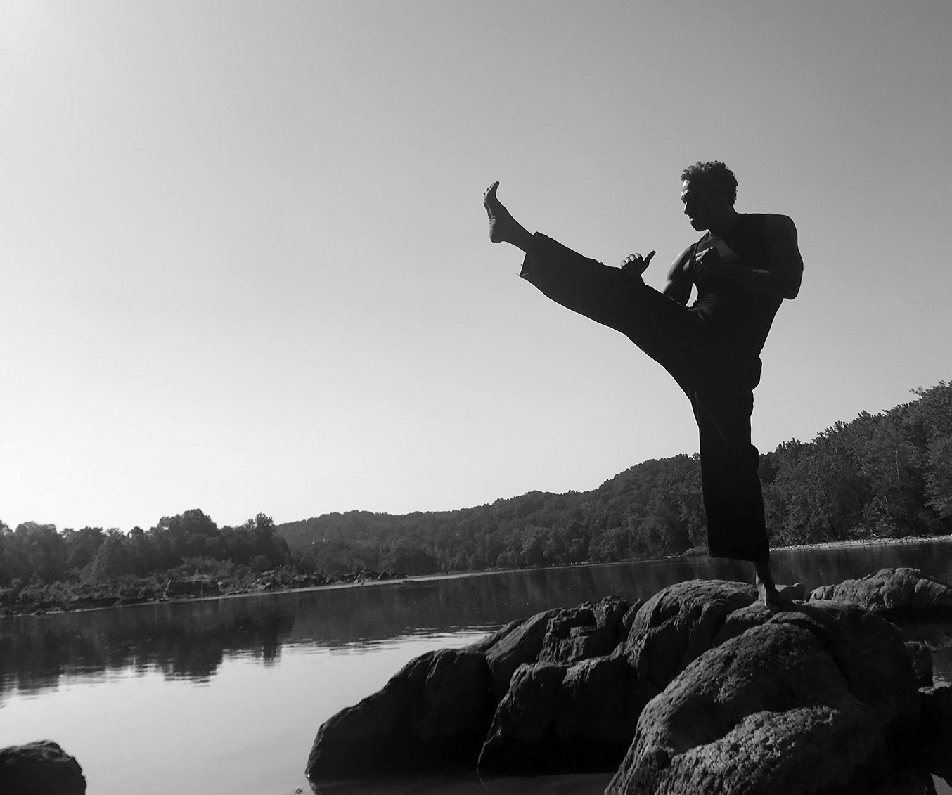 Man doing a front kick in nature.